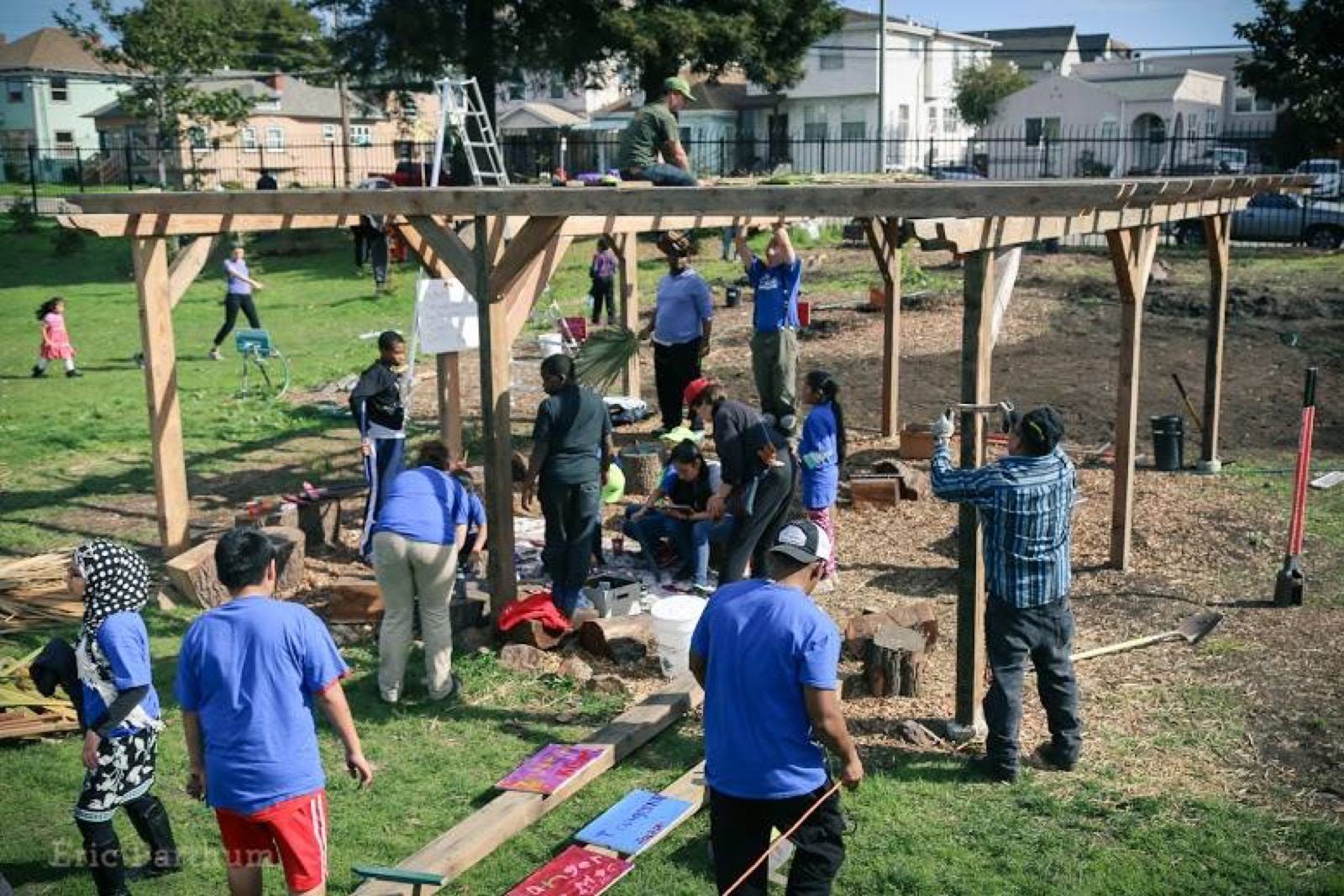 documentary photo, community build day — families & staff installing beds